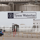 In this May 1, 2020, file photo, vehicles sit in a near empty parking lot outside the Tyson Foods plant in Waterloo, Iowa.